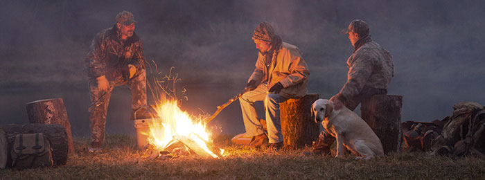 guys around campfire with dog wearing a garmin trashbreaker e collar